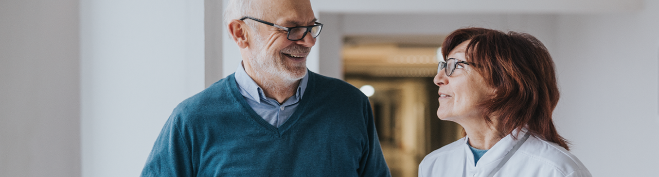 Older male patient smiling with nurse on his side